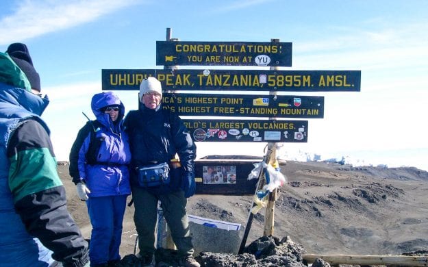 Hikers stand at top of Mt Kilimanjaro