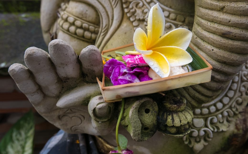 Balinese Hindu offering in the hands of a statue