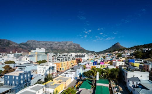 Elevated view of Cape Town with colourful houses in the foreground and Table Mountain and Lion's Head clear blue sky in the background Mother City South Africa