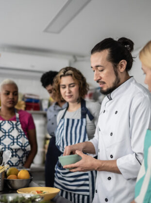 Chef giving instructions to students at cooking class