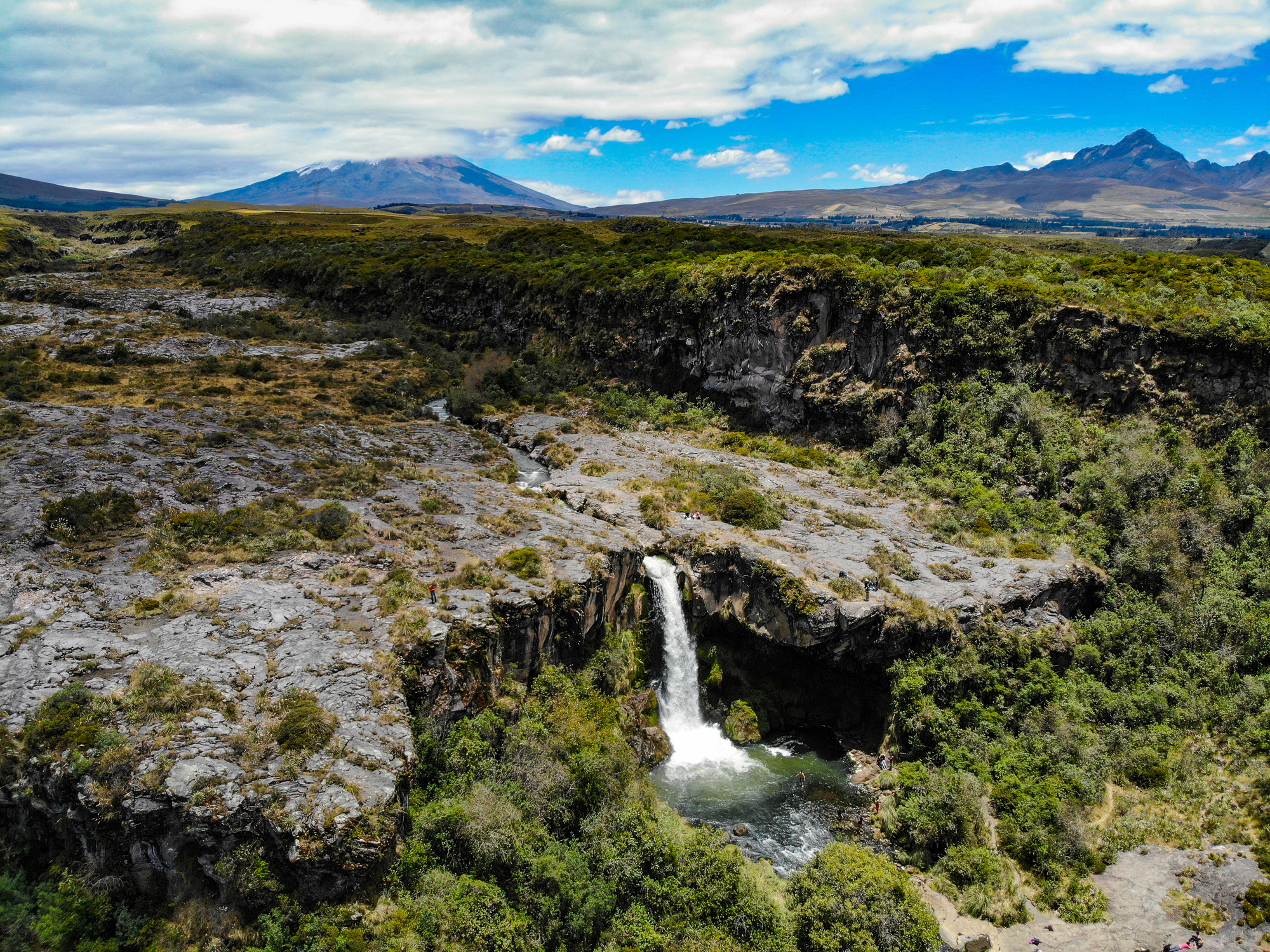 Waterfall formed of crystalline water that is born in the cotopaxi and runs through a channel in volcanic rock