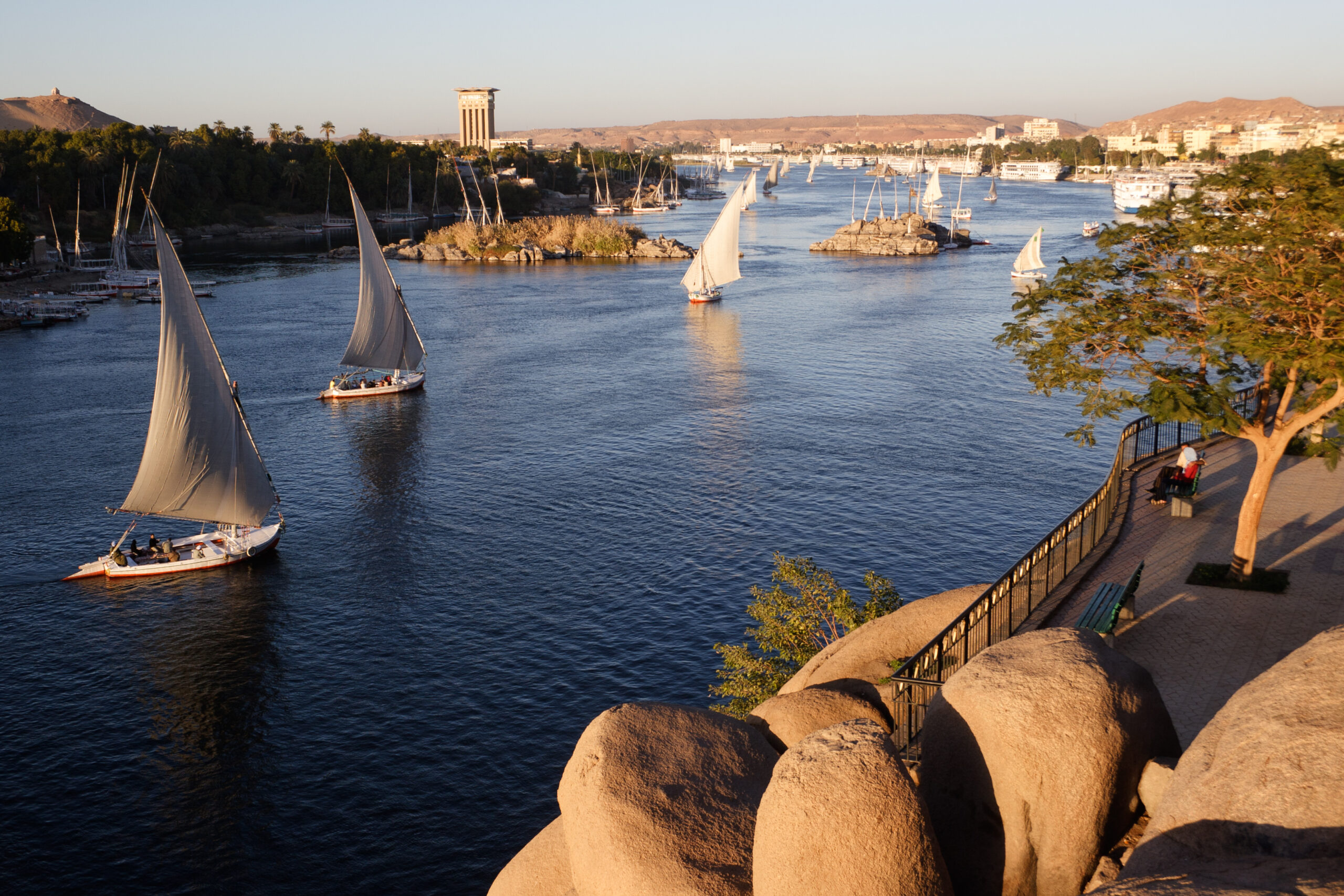 Traditional boats sailing on the Nile river in Aswan, Egypt.